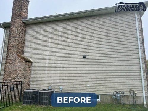 Before power washing, dirty residential siding and outdoor equipment in a suburban setting.