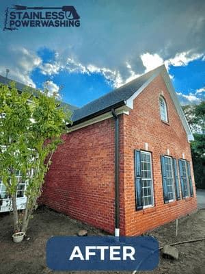 Cleaned brick wall of a house with fresh landscaping, showcasing power washing results.