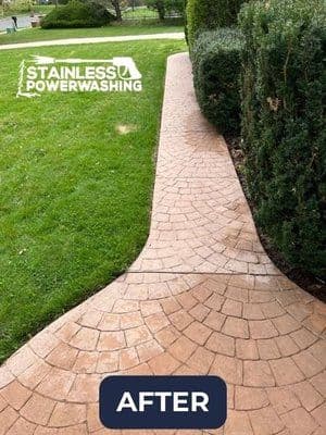 Clean, freshly power-washed brick pathway bordered by green hedges and lawn.