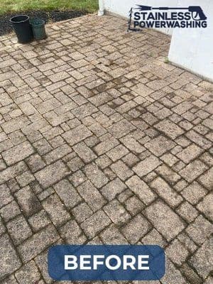 Before power washing, stained concrete patio with visible dirt and grime.